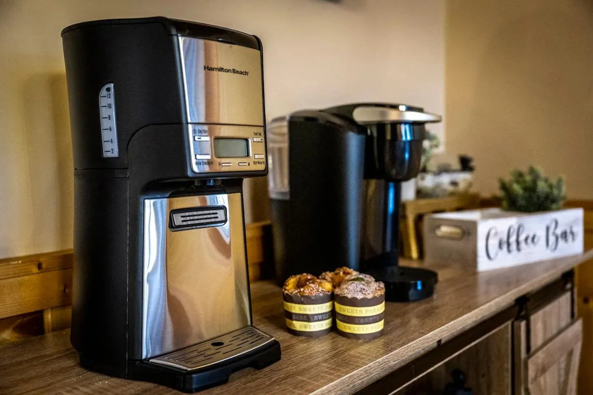 A cozy coffee bar setup features a coffee maker, single-serve brewer, muffins on display, and a 'coffee bar' sign, evoking the inviting morning rituals and casual breakfasts mentioned in the section. The arrangement suggests a welcoming spot for starting the day together.